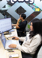 Howdy team members working at their desks in a Howdy House
